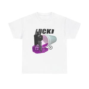 以下が含まれることがあります： 黒色の「LUCKI」の文字、紫と青のカップ、人物が描かれたグラフィックデザインの白いTシャツ。デザインには、紫色の氷のようなベースと登録商標記号が含まれています。