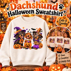 Puede incluir: Una sudadera color crema con un gráfico de tres perros salchicha con disfraces de Halloween, incluyendo una bruja, un fantasma y un mago, rodeados de calabazas y dulces. El texto dice Dachshund Halloween Sweatshirt y Cute & Spooky.