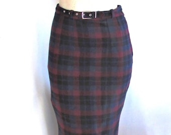 May include: A pencil skirt in a plaid pattern featuring burgundy, navy blue, and black hues. The skirt has a fitted silhouette, a belt with a silver buckle, and a classic design. The skirt is a versatile piece for various occasions.