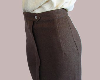 May include: A brown skirt with a wrap-style design. The skirt features a button closure at the waist and a subtle pocket detail. The fabric appears to be a medium-weight material, suitable for various occasions.