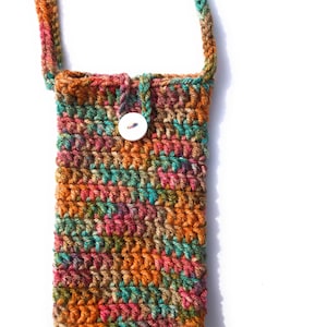 May include: A crocheted phone pouch with a colorful striped pattern in shades of orange, brown, green, and pink. The pouch has a white button closure and a long strap.