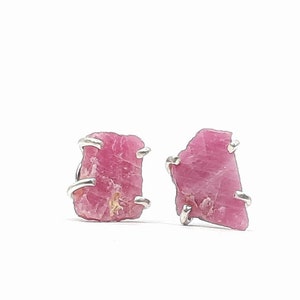 Puede incluir: Un par de pendientes de plata con detalles de piedras preciosas crudas de color rosa.
