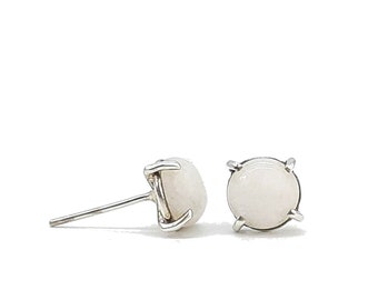 May include: A pair of silver stud earrings with white round gemstones.