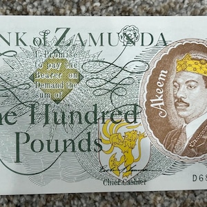 Può includere: Una banconota bianca della Banca di Zamunda, con un ritratto di Akeem con una corona. Il testo recita "One Hundred Pounds" e include il numero "100" in più punti. La banconota ha un design dettagliato.