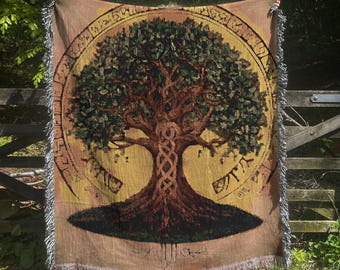 May include: A woven tapestry throw blanket featuring a large, intricate tree of life design with a Celtic knot pattern. The tree is surrounded by a circle of runes and is set against a yellow and brown background.