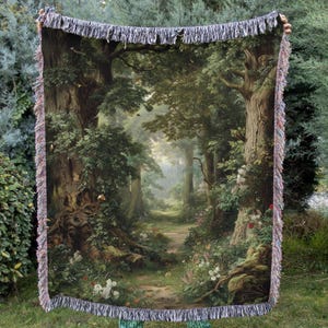 May include: A rectangular woven throw blanket featuring a detailed forest scene with large, textured tree trunks, dense green foliage, and a winding path leading into the distance. The blanket has a decorative fringed edge on all four sides.