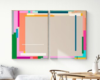 May include: Two abstract art prints with geometric shapes in pink, green, blue, orange, and yellow colors. The prints are framed in gold and hung on a white wall.