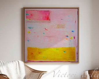 May include: Abstract painting with a pink background, a yellow bottom section, and colourful accents. The painting is framed and hanging on a white wall in a room with a chair and a vase.