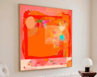 May include: Abstract art print with a large orange square with a smaller orange square inside. The background is a light pink with a white border. The print is hanging on a white wall in a room with a white chair and ottoman.