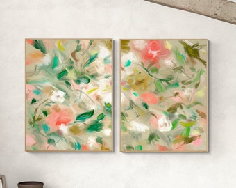 May include: Two framed abstract floral paintings with a neutral background. The artwork features brushstrokes of pink, green, white, and brown. The paintings are displayed in a room with a white wall, a wooden door, and a green blanket.