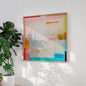 Puede incluir: Pintura abstracta con fondo blanco y formas geom&eacute;tricas coloridas en tonos de rosa, amarillo, azul y naranja. La pintura est&aacute; enmarcada en un marco de madera claro.