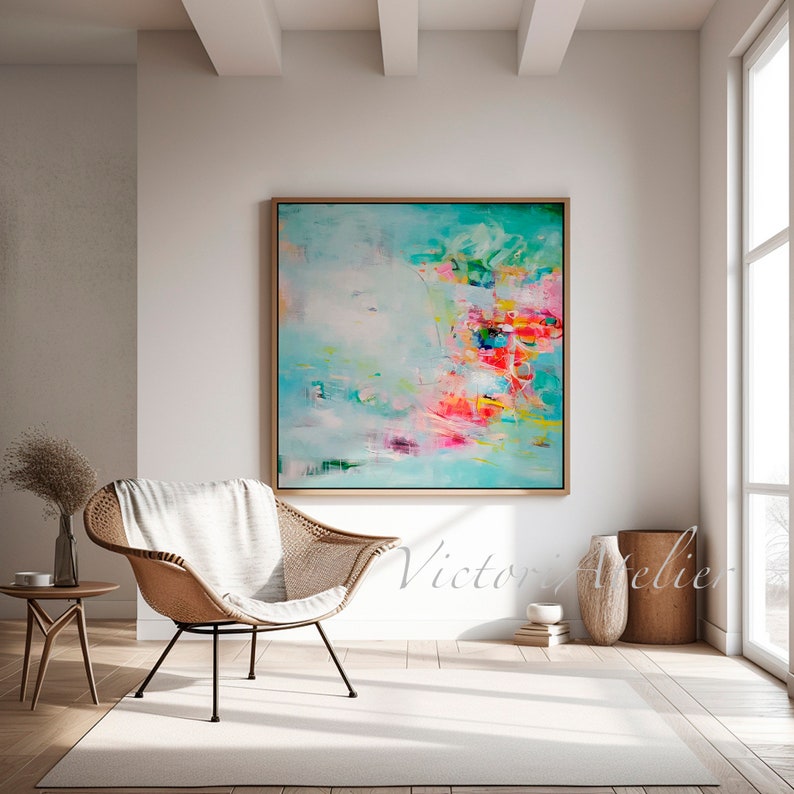 May include: Abstract painting with a turquoise background and colorful brushstrokes in pink, yellow, green, and red. The painting is framed in a light wood frame and is hanging on a white wall.