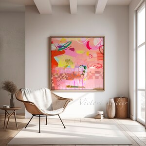 Op de afbeelding: Abstracte schilderij met roze, rood, geel, groen en blauwe kleuren. Het schilderij is ingelijst in een licht houten lijst en hangt aan een witte muur.