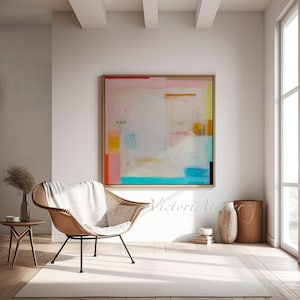 Puede incluir: Pintura abstracta con fondo blanco y formas geom&eacute;tricas coloridas en rosa, azul, amarillo y naranja. La pintura est&aacute; enmarcada en un marco de madera claro y est&aacute; colgada en una pared blanca en un sal&oacute;n.