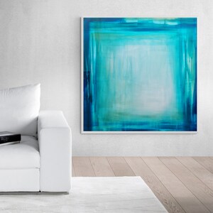 Pode incluir: Arte de parede abstrata com uma composi&ccedil;&atilde;o quadrada em tons de verde-azulado e turquesa. A obra de arte tem uma moldura branca e &eacute; exibida em uma parede branca. A paleta de cores da pintura cria uma atmosfera calma e serena.