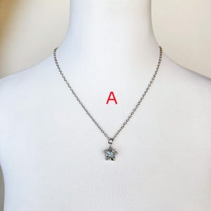 May include: A silver chain necklace with a star-shaped pendant featuring a clear crystal in the center.