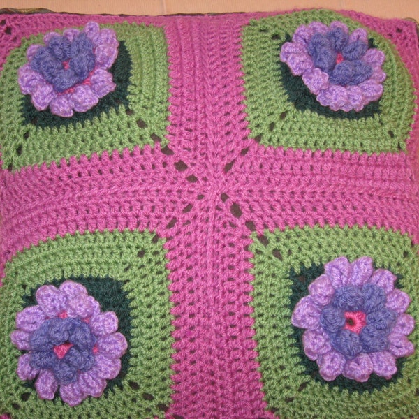 Crochet pillow cover with flowers in three dimensions within 4 granny squares