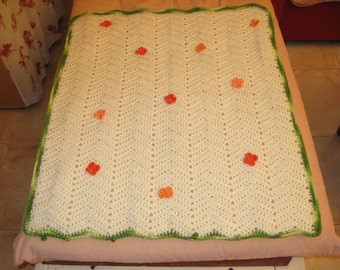 Baby blanket with orange knitted flowers