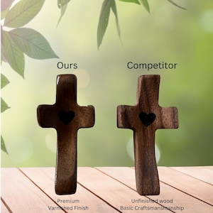 May include: Two wooden crosses with heart cutouts are displayed. The left cross has a premium varnished finish, while the right cross is unfinished. The text "Ours" and "Competitor" are above the crosses.