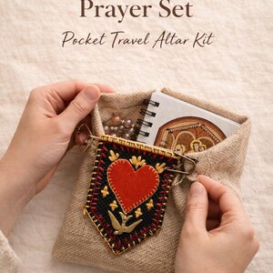 May include: A linen pouch containing a Sacred Heart Prayer Set, a Pocket Travel Altar Kit. The kit includes a small notebook, rosary beads, and a decorative banner with a red heart and gold accents. Text on the image reads "Faith Wherever You Go."