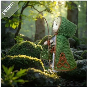 May include: A handmade crochet doll wearing a green hooded cape with an orange Celtic knot design. The doll holds a wooden bow and arrow. The word "pattern" is in the upper left corner. The doll is set against a mossy forest background.