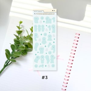Puede incluir: Una hoja de pegatinas con figuras de dibujos animados de color azul claro en varias poses y expresiones. La hoja incluye el texto "Miso's Market" y "silly green guys" en un dise&ntilde;o de barra de b&uacute;squeda. El n&uacute;mero "#3" est&aacute; impreso en la parte inferior.