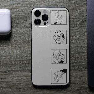 May include: A white iPhone case with a black outline and four black squares with a hand gesture in each square. The hand gestures are a thumbs up, a fist, a handshake, and a peace sign.