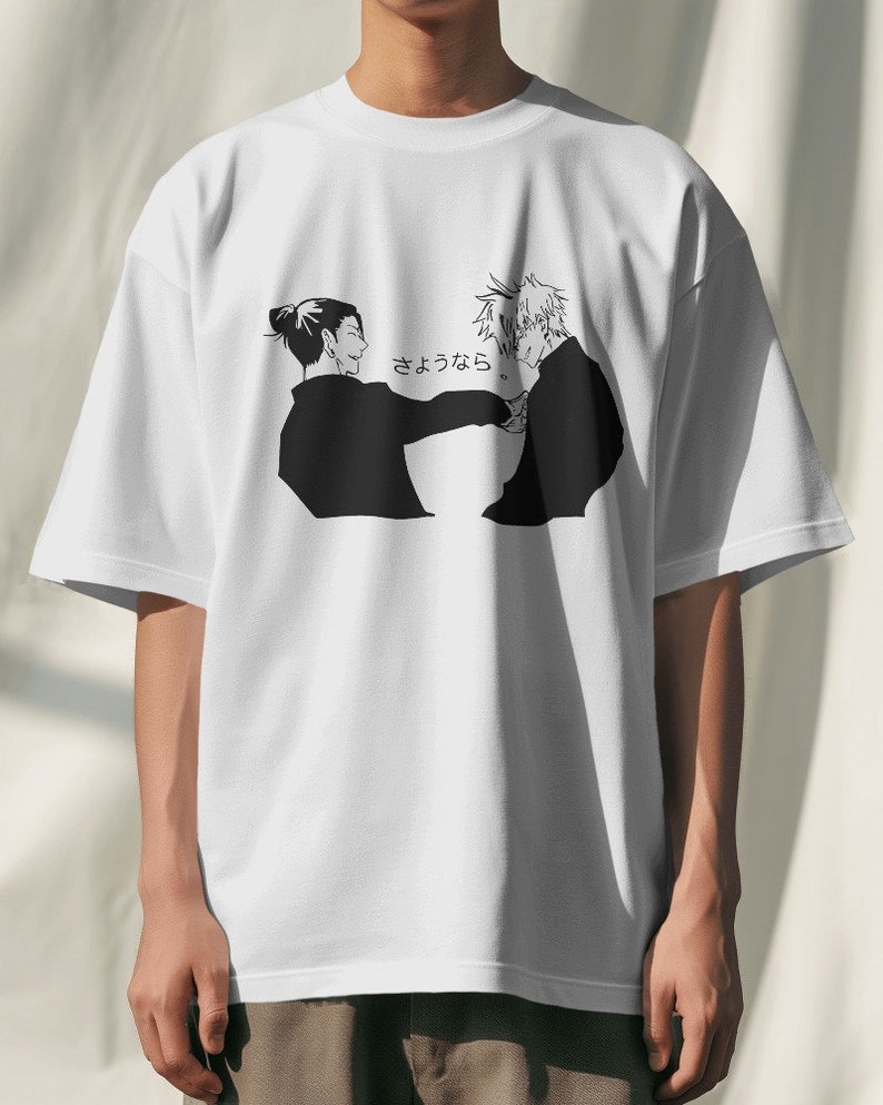May include: White t-shirt with a black and white illustration of two people facing each other. The text "さよなら" is printed on the shirt.
