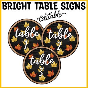 Könnte beinhalten: Drei kreisförmige Tischschilder mit dunklem Holzmaserungshintergrund und hellem Holzrand. Jedes Schild zeigt weißen Schreibschrifttext mit table 1, table 2 oder table 3, umgeben von gelben, orangen und roten Herbstahornblättern. Text BRIGHT TABLE SIGNS editable.