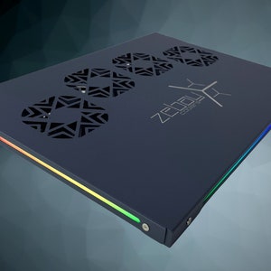 May include: A dark gray rectangular device with a black and white logo that says "ZEBULON CORE" and three circular vents with a geometric pattern. The device has a multi-colored light strip along the edge.