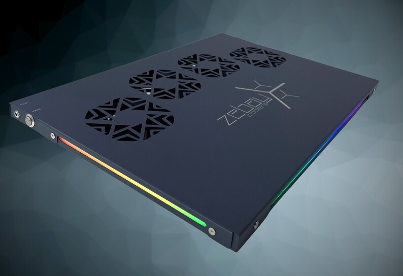 May include: A dark gray rectangular device with a black and white logo that says "ZEBULON CORE" and three circular vents with a geometric pattern. The device has a multi-colored light strip along the edge.