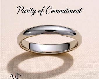 May include: A polished silver-toned metal band ring with a smooth, rounded surface. The text Purity of Commitment is printed above the ring, and the word Platinum is printed below. A stylized AS logo is visible in the bottom left corner.