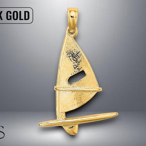May include: A gold pendant in the shape of a sailboat. The pendant is made of 14K gold and features a detailed design of the sail, mast, and hull. The pendant has a loop at the top for attaching to a chain.