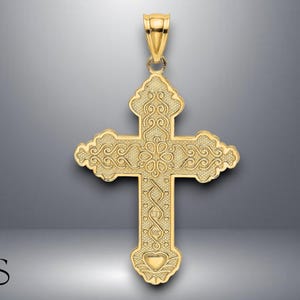 Könnte beinhalten: Goldfarbener Anhänger in Form eines Kreuzes. Das Kreuz weist aufwendige Schnörkel und ein herzförmiges Design am unteren Ende auf. Der Anhänger hat eine Öse zum Anbringen an einer Kette. Das Design ist aufwendig und detailliert.