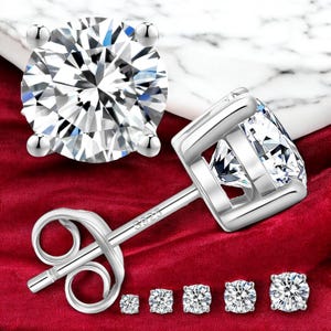 May include: A set of six silver stud earrings with clear cubic zirconia stones. The earrings are shown on a red velvet background. The earrings are available in different sizes.