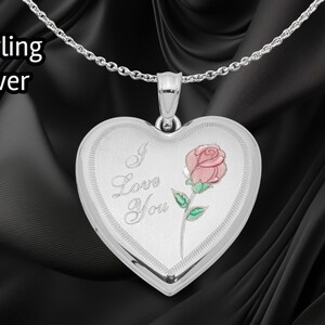 May include: A sterling silver heart-shaped locket pendant on a chain. The locket features the words "I Love You" and a pink rose with green leaves. The text "Sterling Silver" is in the upper left corner.