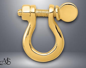 Pode incluir: Um fecho de metal dourado com um design de parafuso. O fecho tem a forma de um U com uma maçaneta arredondada em uma extremidade.
