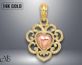 Könnte beinhalten: Goldener Anhänger mit herzförmigem Mittelteil und aufwendigem Filigran-Design. Das Herz ist roségoldfarben, und der Anhänger ist mit "14K GOLD" markiert. Er hat eine Schlaufe für eine Kette.