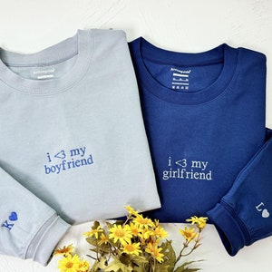 May include: Two long-sleeved shirts with embroidered hearts and text. The light blue shirt says "i <3 my boyfriend" and the navy blue shirt says "i <3 my girlfriend".