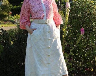 Gonna midi in cotone bianco ricamata: vita alta, linea ad A, con tasche.