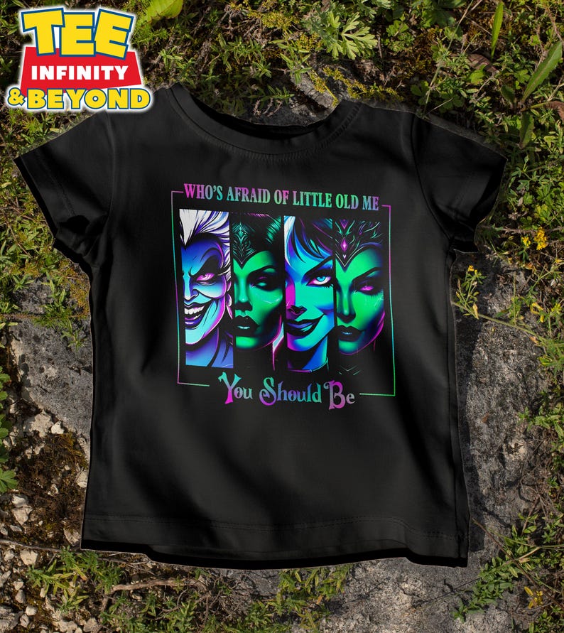 May include: Black t-shirt featuring a colorful graphic of four stylized villainous faces with the text "WHO'S AFRAID OF LITTLE OLD ME - YOU SHOULD BE". The graphic has neon green, blue, and purple accents.