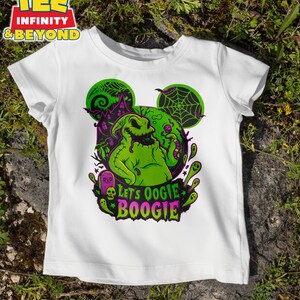 K&ouml;nnte beinhalten: Wei&szlig;es T-Shirt mit einem gr&uuml;nen Oogie Boogie-Design, einschlie&szlig;lich eines Spukhauses, Spinnweben und dem Text "Let's Oogie Boogie". Das Design hat die Form von Mickey Mouse-Ohren, ideal f&uuml;r Halloween.