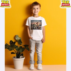 May include: A child wearing a white t-shirt with a cartoon graphic. The child is also wearing grey trousers and white trainers. The background is a yellow wall with a potted plant. The t-shirt has the text "TEE INFINITY & BEYOND".