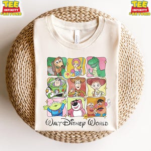 Puede incluir: Camiseta color crema con una cuadr&iacute;cula de personajes de dibujos animados de Toy Story, incluyendo a Woody, Buzz Lightyear y Rex. Las palabras "Walt Disney World" est&aacute;n impresas en negro en la parte inferior.
