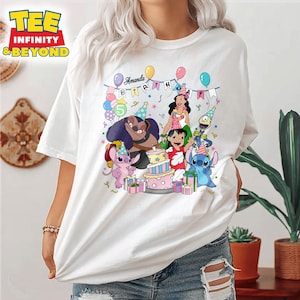 May include: White t-shirt with a colourful graphic of Lilo & Stitch characters at a birthday party. The design includes a cake, balloons, and the name "Amanda". The shirt has short sleeves and is made of a soft material.