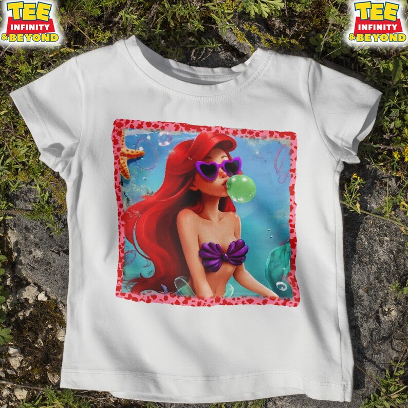 May include: A white ceramic mug with a black handle and the text "But First, Coffee" in a bold, black font. The mug is set against a neutral background, highlighting its simple design.