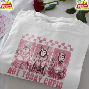 May include: White t-shirt featuring a pink graphic with three cartoon villains, each holding a drink or an apple. The text "NOT TODAY CUPID" is printed in pink below the graphic. The shirt has a crew neck and short sleeves.