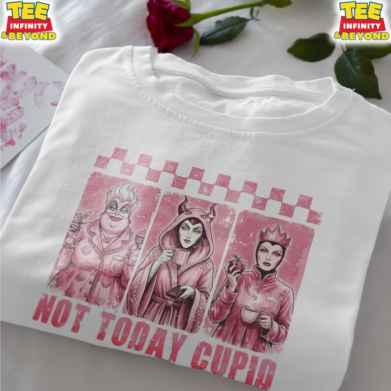 May include: White t-shirt featuring a pink graphic with three cartoon villains, each holding a drink or an apple. The text "NOT TODAY CUPID" is printed in pink below the graphic. The shirt has a crew neck and short sleeves.