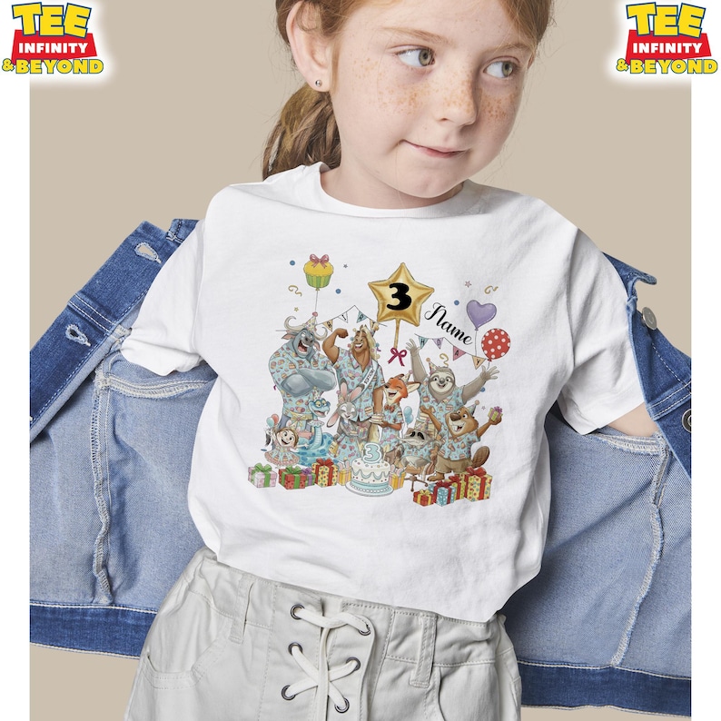Puede incluir: Camiseta blanca con un gr&aacute;fico colorido de animales de dibujos animados celebrando un cumplea&ntilde;os. El n&uacute;mero "3" se muestra en una estrella, con la palabra "Name" debajo. Tambi&eacute;n se muestran globos, regalos y una tarta.