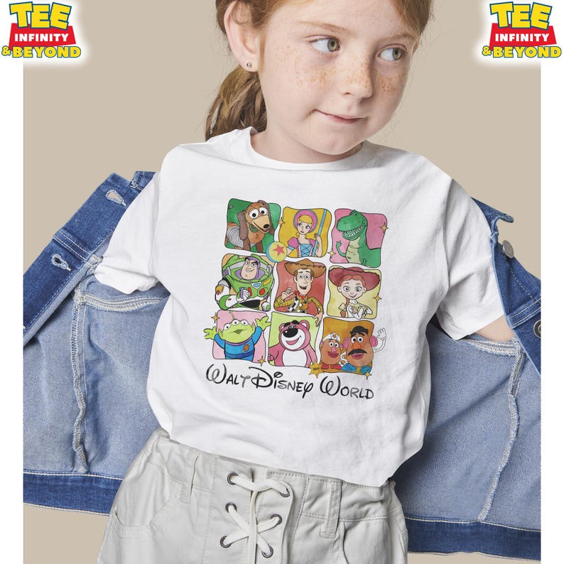 Puede incluir: Camiseta blanca con una cuadr&iacute;cula de im&aacute;genes de personajes de dibujos animados coloridos de la pel&iacute;cula Toy Story. La camiseta incluye el texto "Walt Disney World" en una fuente cursiva. La camiseta la lleva una persona joven.